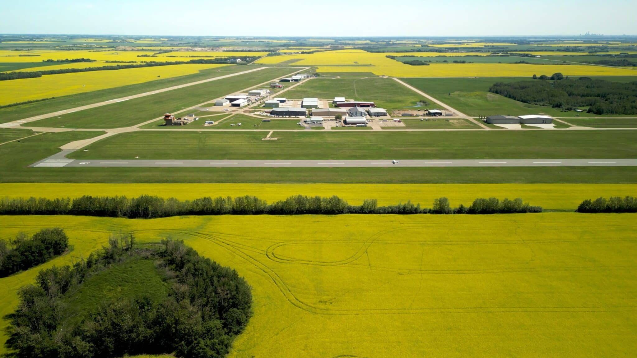 Aerial view of airport surrounded by yellow fields.